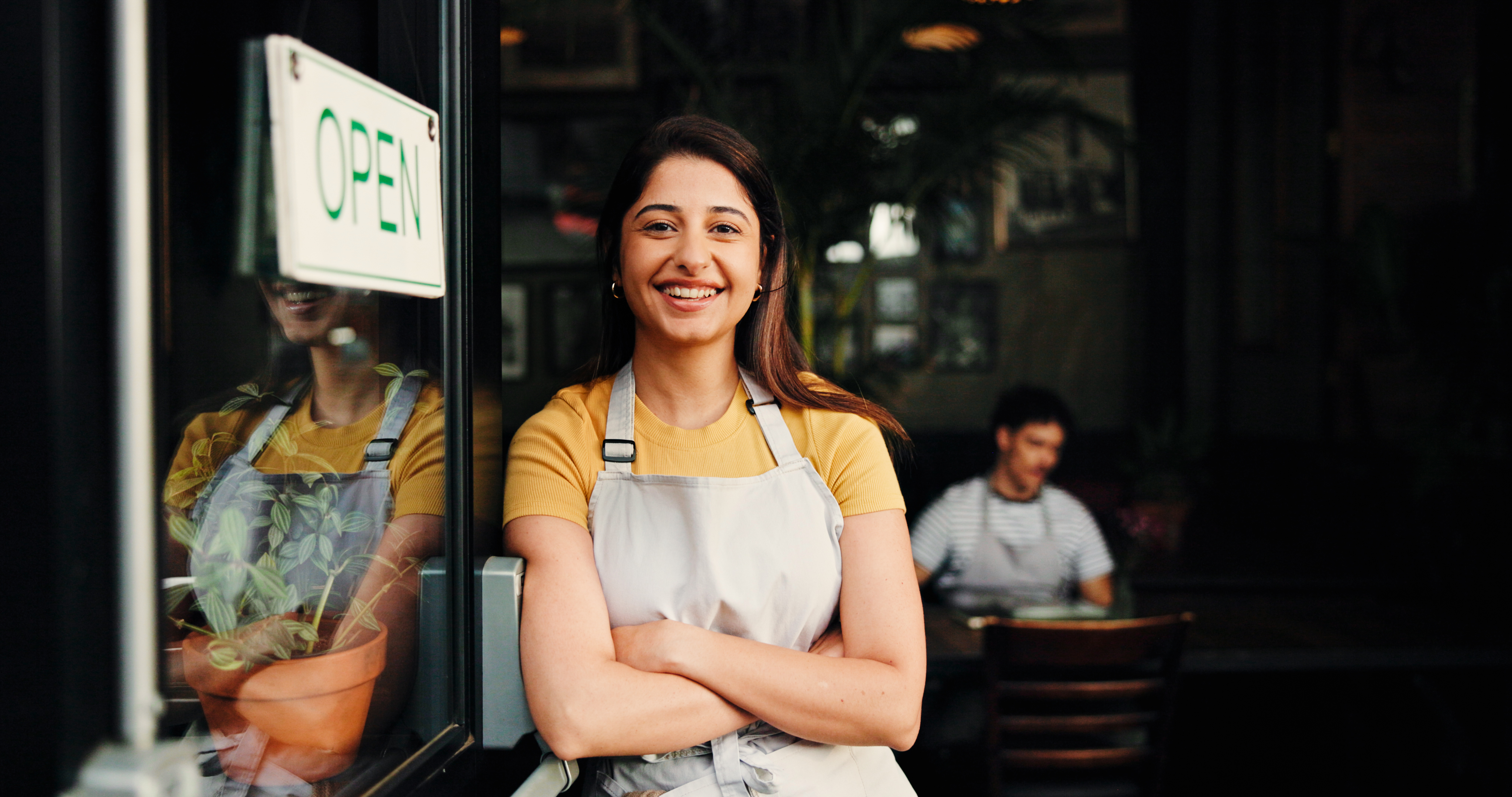 Local business owner standing by an open storefront